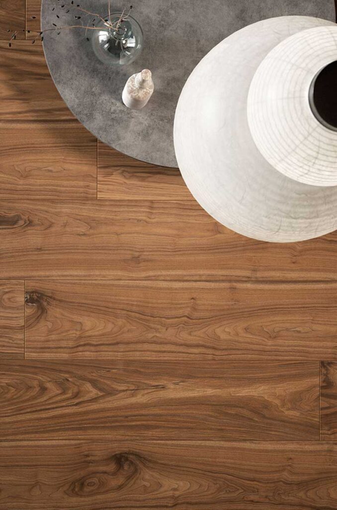 Runder Holztisch mit grauer Platte und Vase neben weißer Lampe auf Holzfußboden