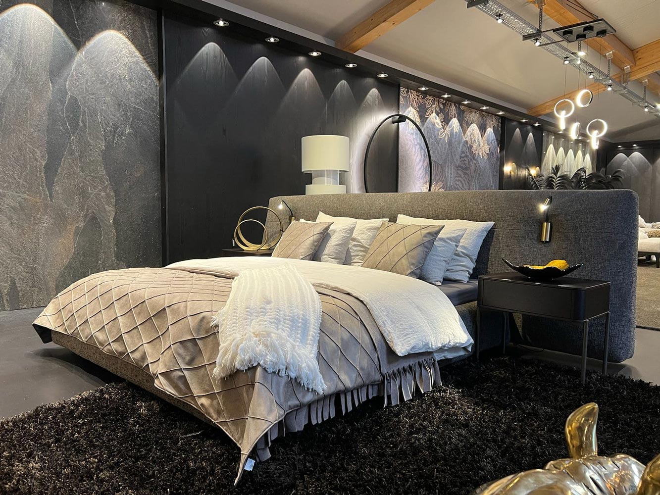 Elegantes Schlafzimmer in Grautoenen mit Doppelbett und stimmungsvoller Beleuchtung